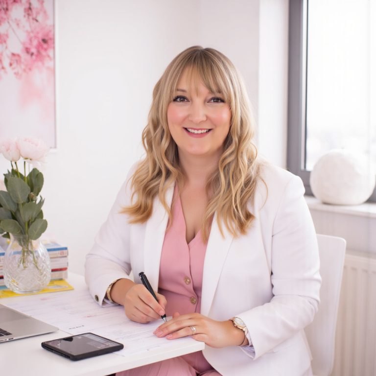 Dr Nikki Ramskill, women's health GP, smiling at her desk in clinic.
